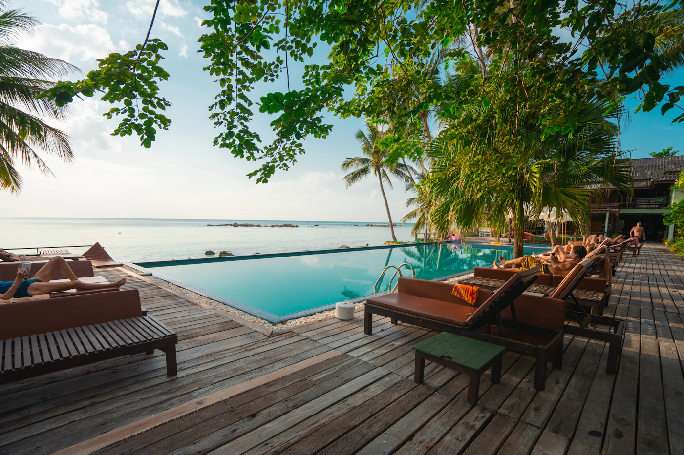 A wooden deck and infinity pool looking out to sea